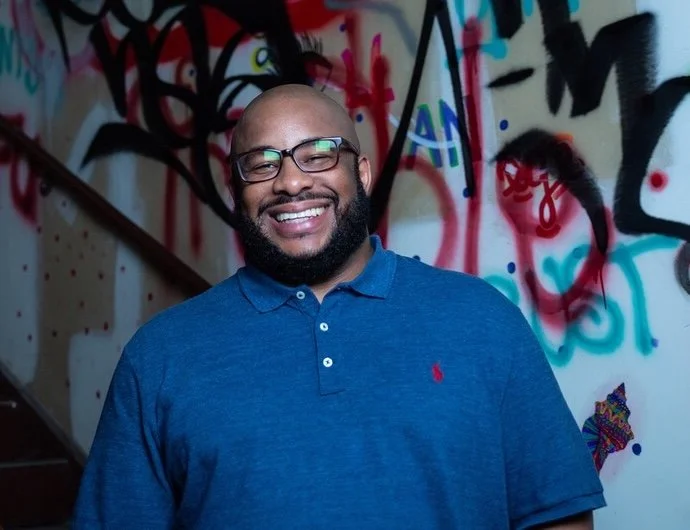 Reggie White in front of a colorful graffiti wall